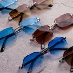 Mehrere Modische Sonnenbrillen Mit Blauen Und Braunen Gläsern, Produktfotografie Auf Strukturiertem Hintergrund.