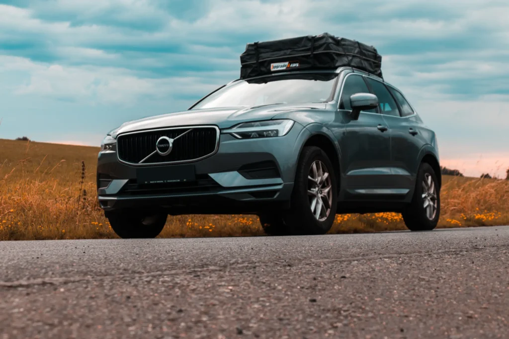 Volvo XC60 SUV auf Landstraße mit Dachzelt bei bewölktem Himmel