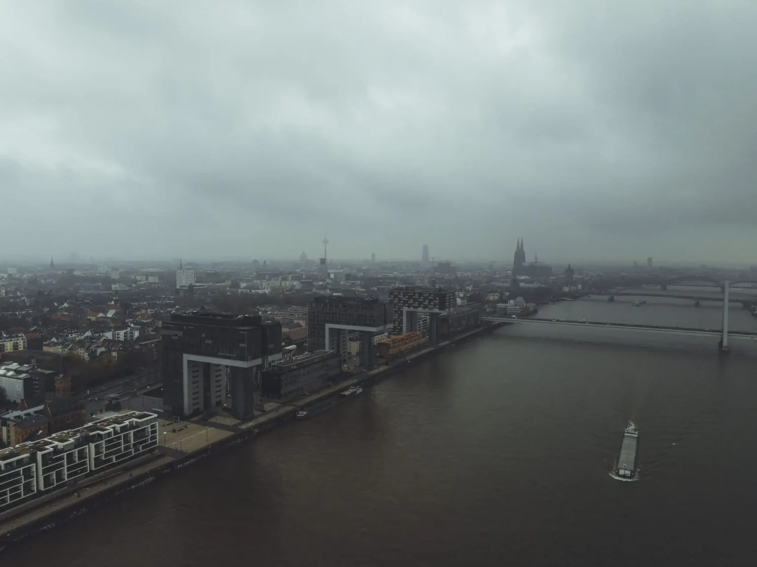 Luftaufnahme von Köln mit Rhein und Kranhäusern bei bewölktem Himmel