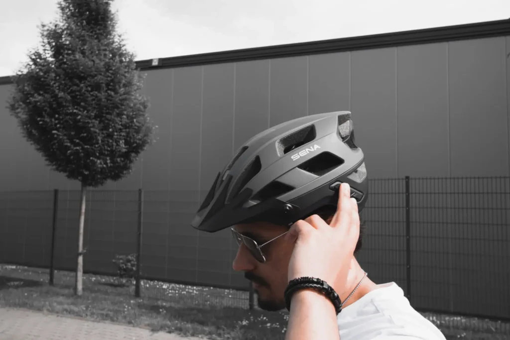 Mann mit SENA Fahrradhelm, der die Kommunikationsfunktion testet